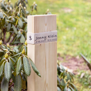 Holzkreuz ÜHolz® Jonny Jura mit Symbol auf dem Friedhof.