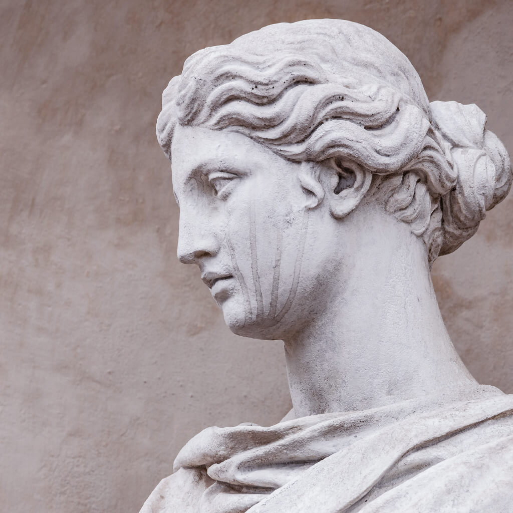 Junge Frau in Naturstein mit würdevollem Blick und Tränen im Gesicht