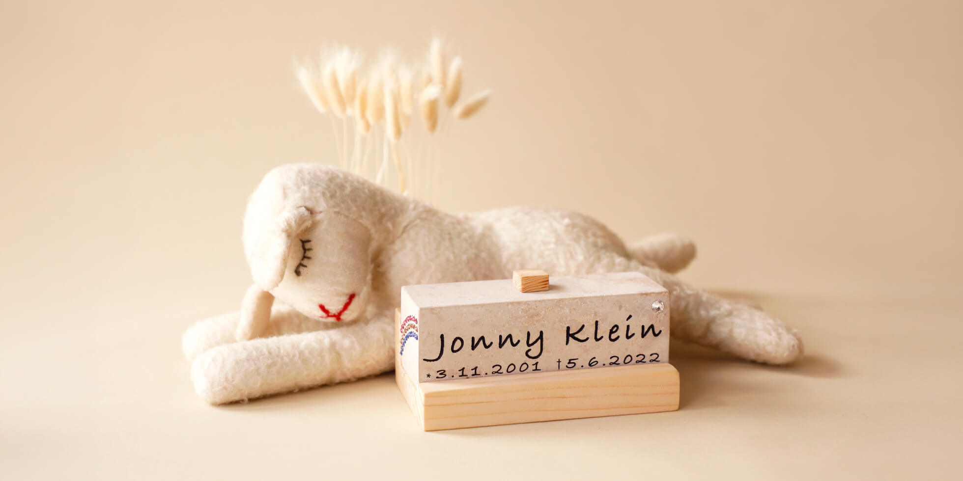 ÜHolz Jonny Namensstein zu Hause neben einem kleinen Kuscheltier